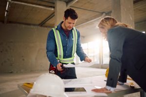 Profesionales revisando planos para calcular cuánto cuesta construir una casa económica en Estados Unidos.